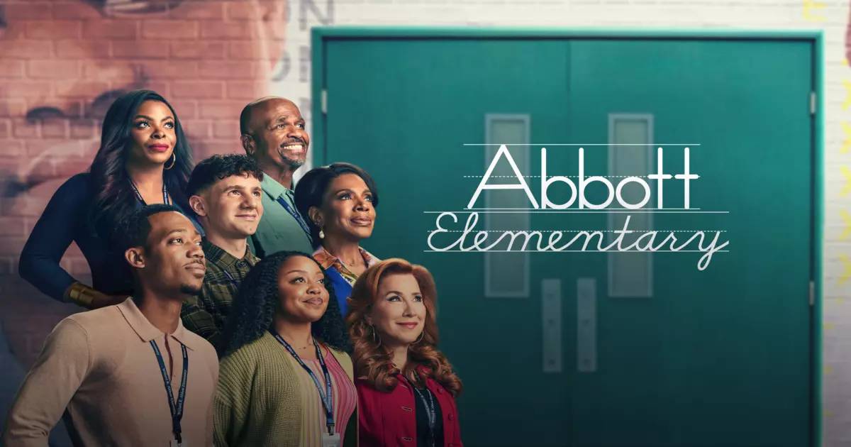 Group of people posing in front of a green door, with a mural featuring a famous figure in the background. 