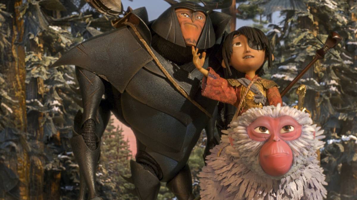 A large, armored figure stands beside a young girl in a vibrant, layered outfit, amidst a misty, enchanted forest setting. Scene of film - Kubo and the Two Strings .