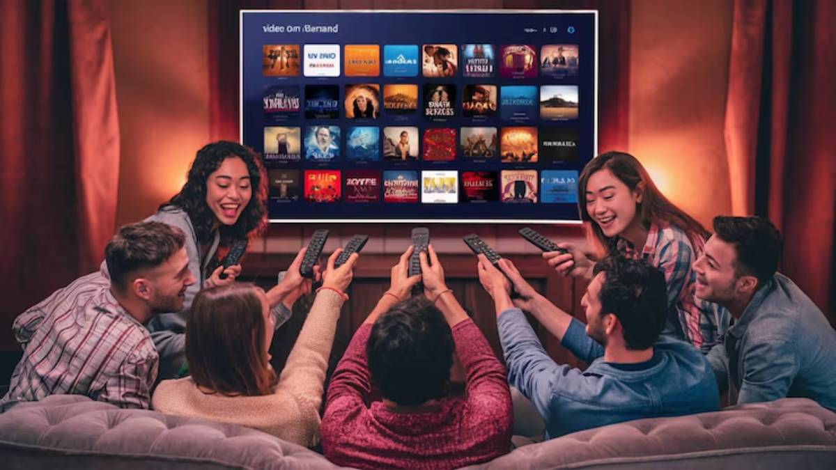 A group of friends sitting on a couch, each holding remote controls, focused on a large TV displaying streaming options.